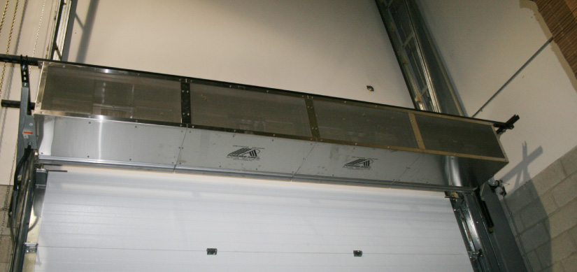 Air curtain mounted above an overhead door