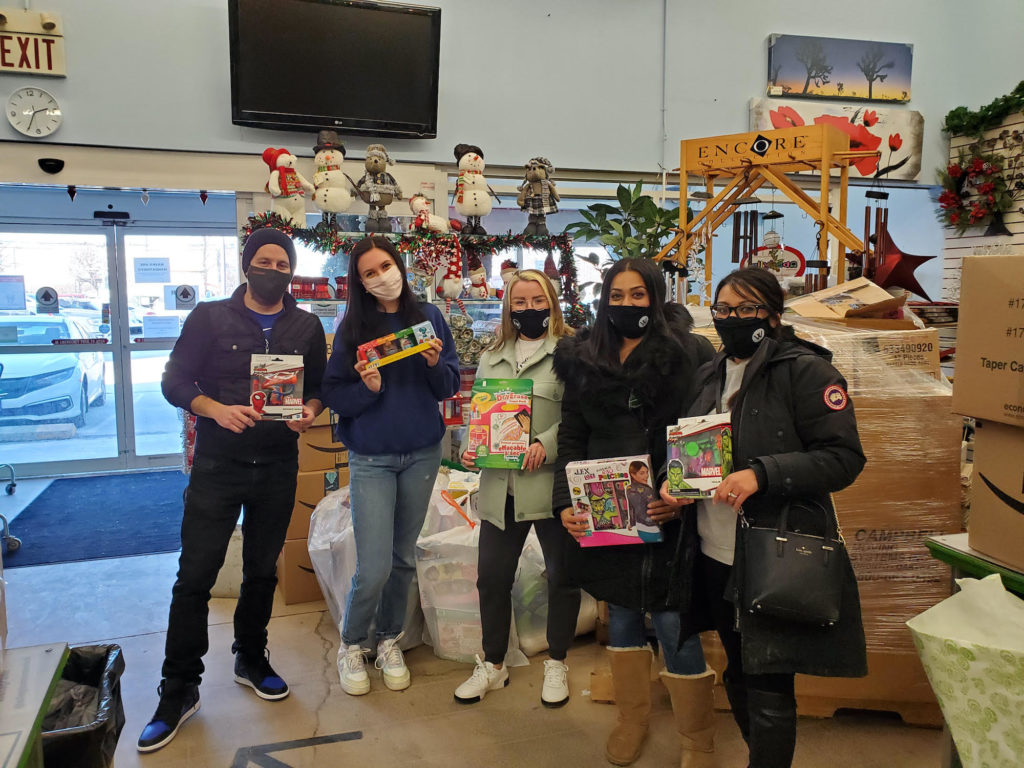 Wilcox team members giving gifts to charity for toy drive