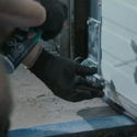 Technician using a power tool on an overhead door