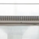 Air curtain mounted above a commercial door opening