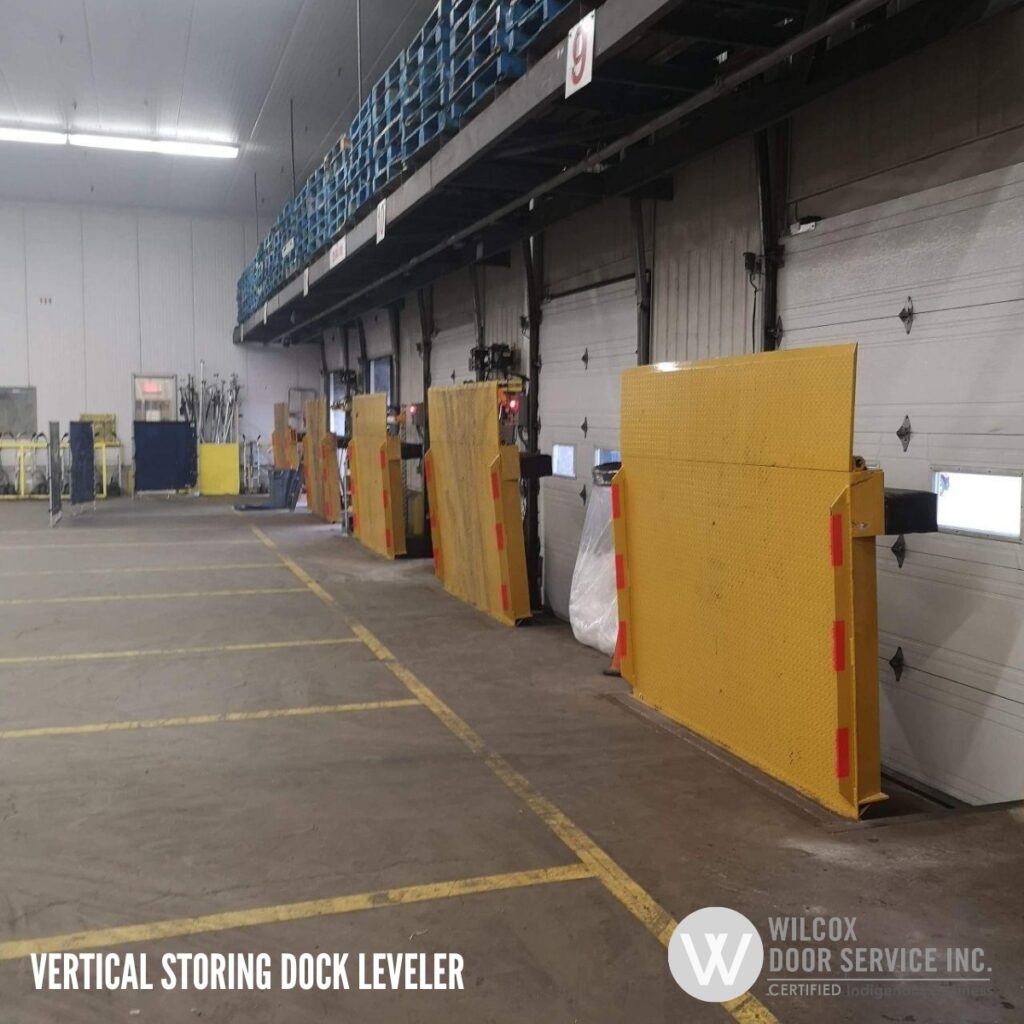 Upright dock levelers along an interior loading area