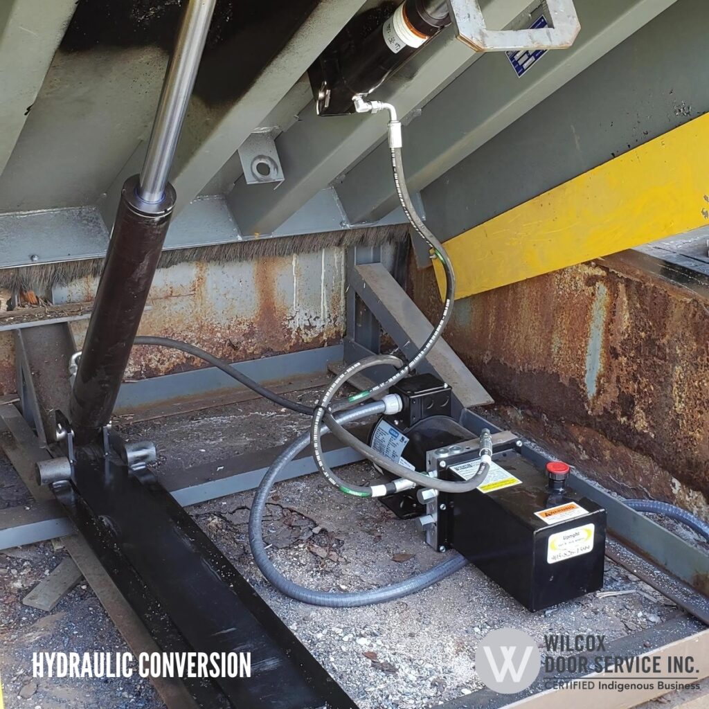 Hydraulic dock leveler conversion equipment installed below the platform