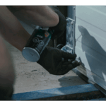 Technician working on an overhead door with a power tool