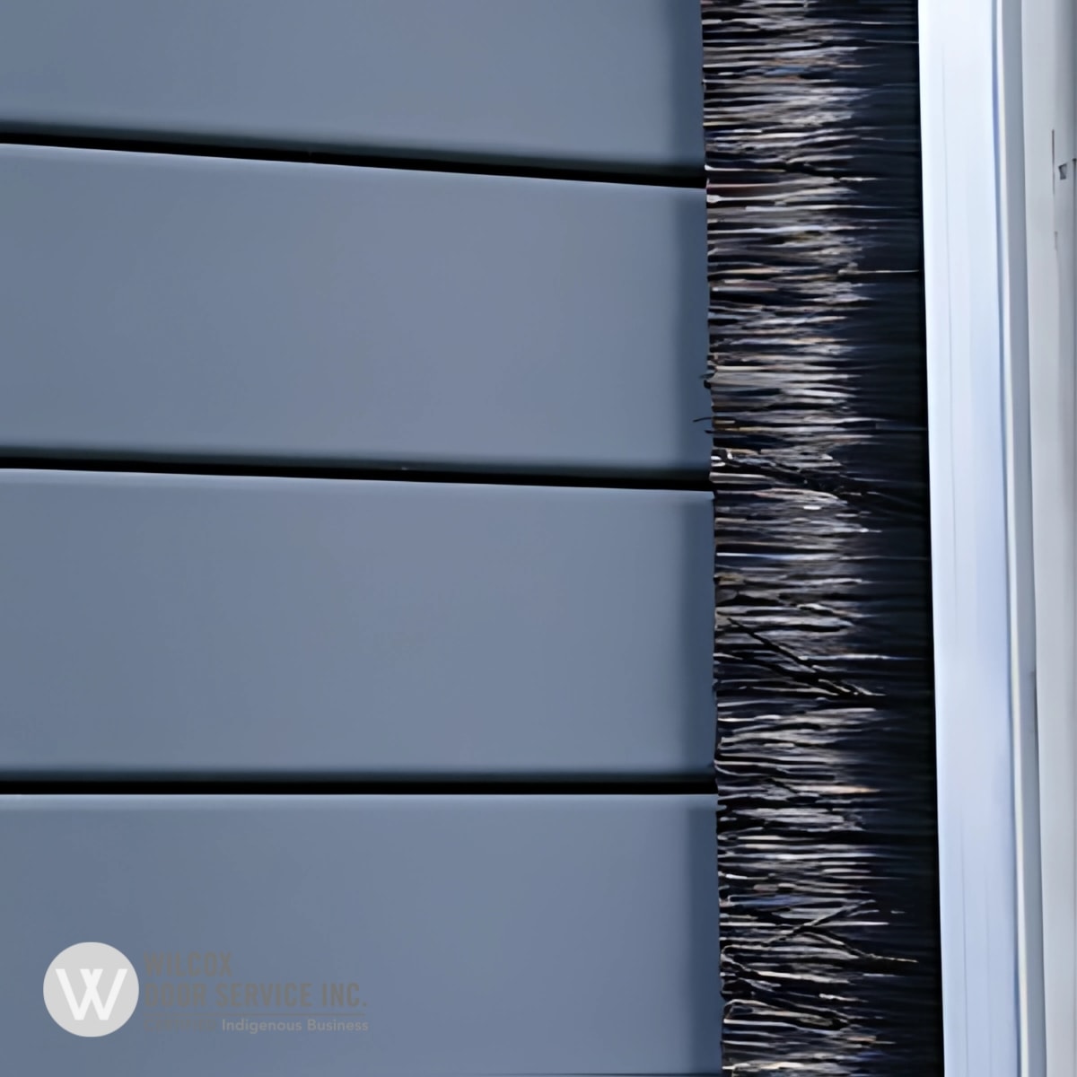 Brush weather seal beside a sectional overhead door