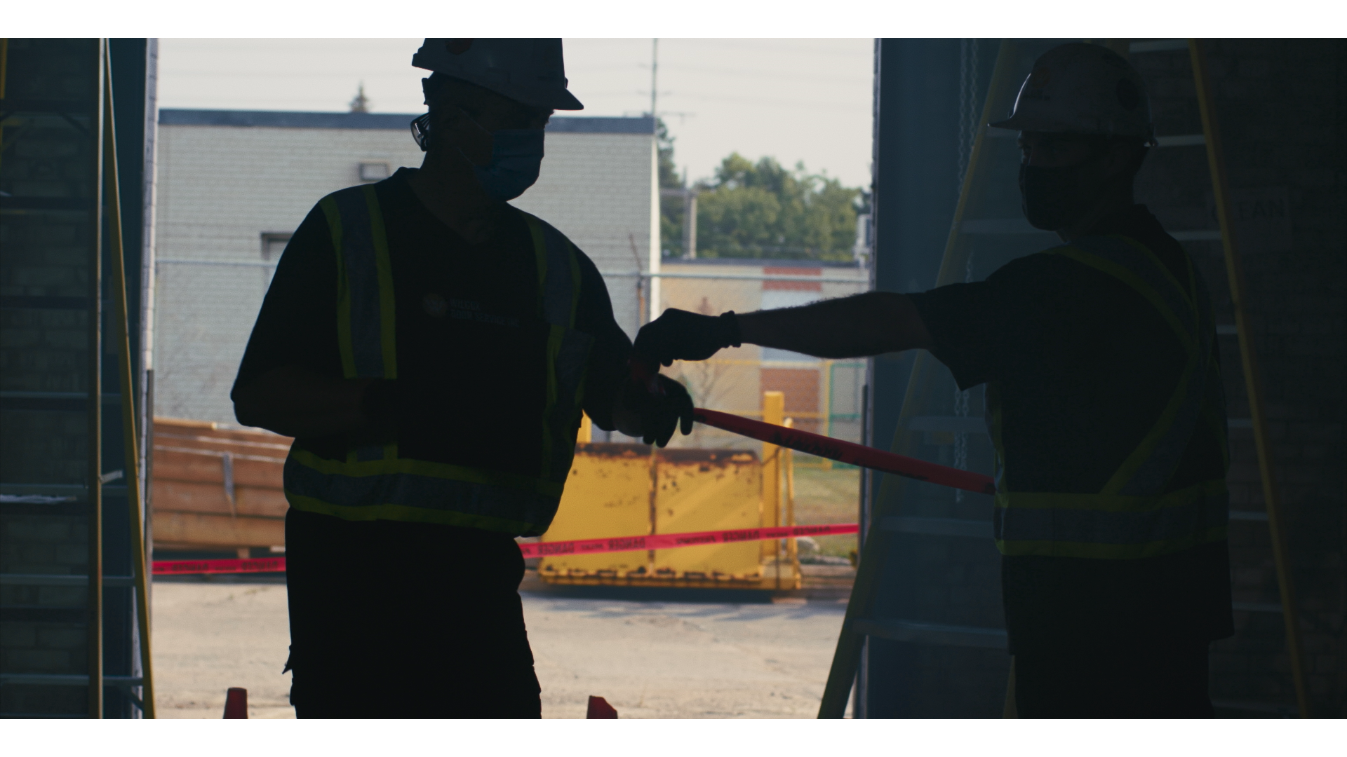 Two technicians reviewing work at a commercial door